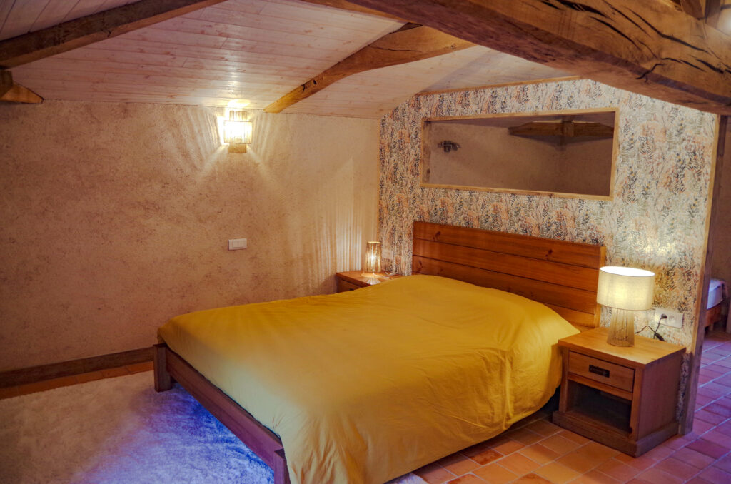 Chambre d'hôte à La Perdrière, Bournezeau, avec un grand lit 160x200. Chambre de charme, à la ferme, avec charpente apparente, sol en tomettes et décoration moderne.